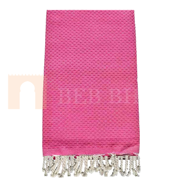 Fouta tissée en nid d'abeille de couleur rose. Elle est multi-usage, en serviette de plage ou de Hammem mais aussi dans la décoration